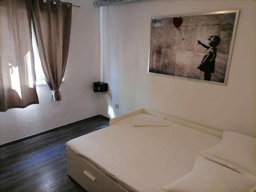 Habitación blanca con cama y una foto en la pared en Apartment Luka en Tučepi