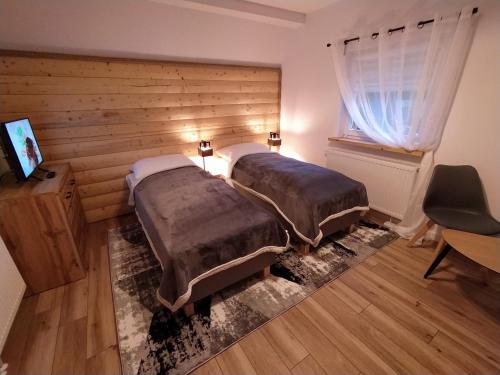 1 dormitorio con 2 camas y ventana en Sosnowa Chata - dom z prywatną sauną, en Szklarska Poręba