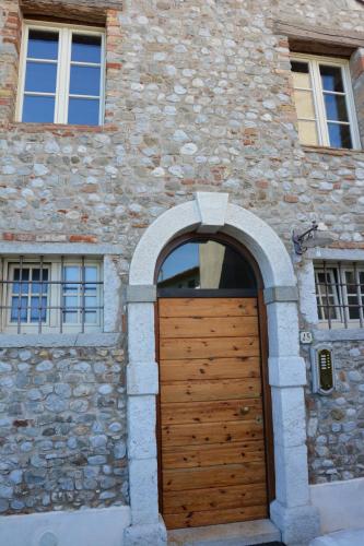 a wooden door in a stone building with an arch at Apartment Monika in Udine