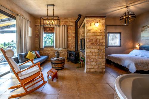 a bedroom with a bed and a tub in a room at At Gil's and Galit's Place- Hospitality, Health and Spa in Bruchim Qela' Alon
