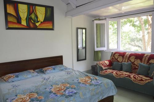 a bedroom with a bed and a couch and a window at Dingle House , A Heritage House in Dalhousie