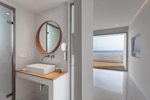 a bathroom with a sink and a mirror at Infinity View Hotel Tinos in Tinos