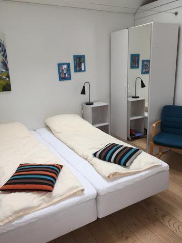 a bedroom with two beds and a blue chair at BB-Risskov in Risskov