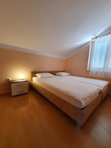 a bedroom with a large bed and a window at apartments oaza, vrsi mulo in Vrsi