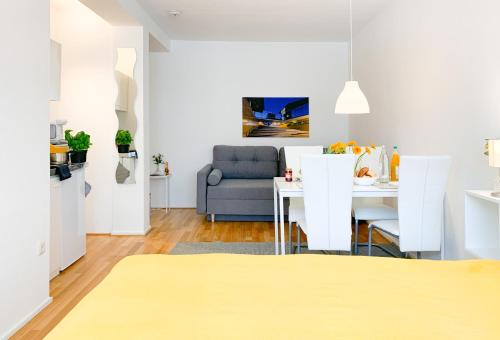 - un salon avec une table et un canapé dans l'établissement Relax Aachener Boardinghouse Appartements Premium 1, à Aix-la-Chapelle