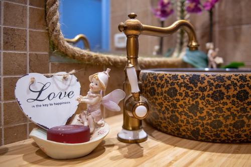 a bathroom sink with a figurine of a girl in a bowl at At Gil's and Galit's Place- Hospitality, Health and Spa in Bruchim Qela' Alon