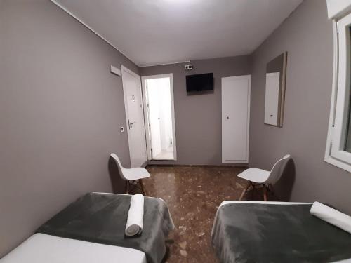 um quarto de hospital com duas camas e duas cadeiras em AYAMONTE ROOMS 43 em Ayamonte