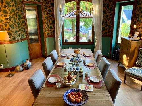 ein Esszimmer mit einem langen Tisch mit Essen drauf in der Unterkunft Villa St. Hubert in Saint-Nectaire