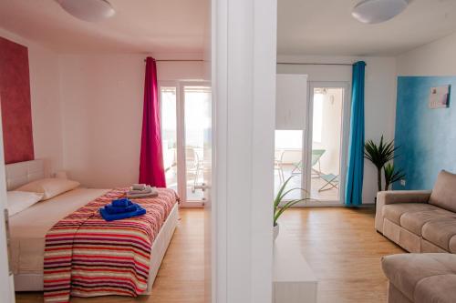 a bedroom with a bed and a living room with a couch at Exclusive Seaside Dream Apartments in Murter