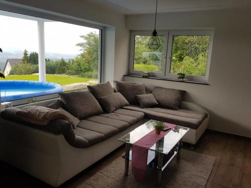 a living room with a couch and a large window at Staufenalpe Hohenstaufen in Göppingen