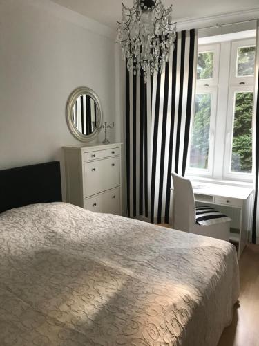 a bedroom with a bed and a desk and a chandelier at Komfortwohnung Leipzig Zentrum-Nord in Leipzig