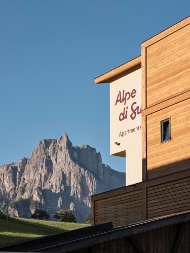 a sign on a building with a mountain in the background at Alpe di Susi in Castelrotto