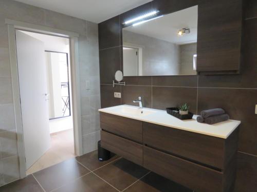 een badkamer met een wastafel en een spiegel bij Kitrino in Geel