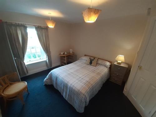 a small bedroom with a bed and a window at The White Hart Inn in Tetford
