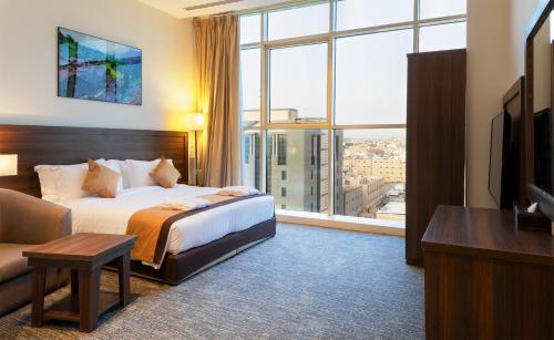 a hotel room with a bed and a large window at Seiba Hotel Apartments-Riyadh in Riyadh