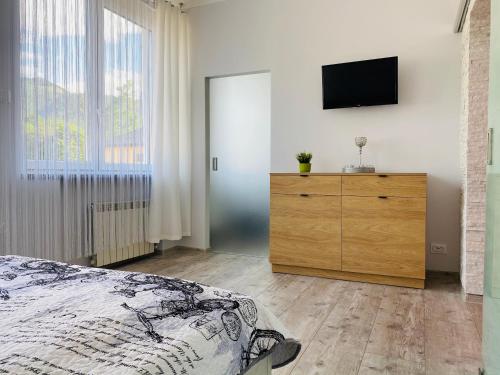 a bedroom with a bed and a dresser with a television at Apartament Rodzinny Centrum Zakopane in Zakopane