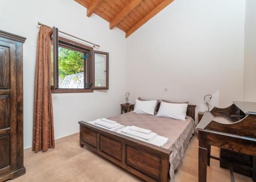 a bedroom with a bed and a desk and a piano at Kerithra Villa in Vasiliki