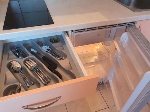 an open drawer with utensils in a kitchen at apartments oaza, vrsi mulo in Vrsi