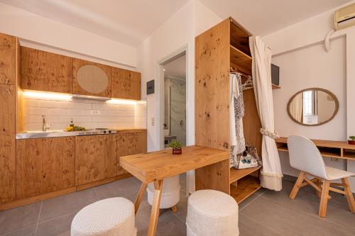 a kitchen with wooden cabinets and a wooden table and chairs at Spiros Family Apts in Laganas