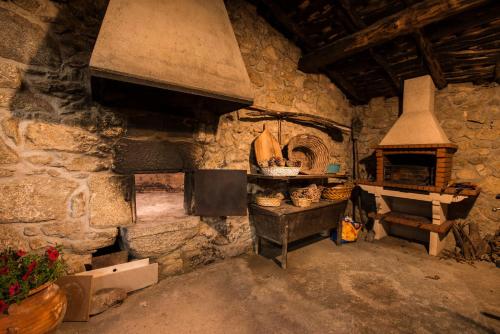 a kitchen with an oven in a stone building at Aldeade in Ferreira de Panton