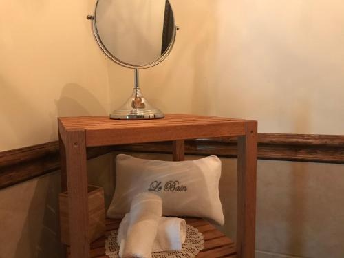 a table with a mirror and towels on it at Domaine de la Baie, Les Suites in Shawinigan
