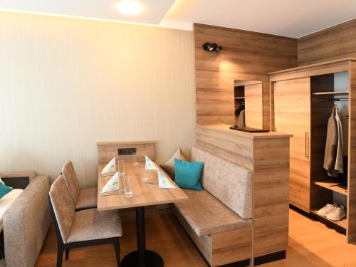 a dining room with a table and a couch at WESTSIDE Hotel in Munich