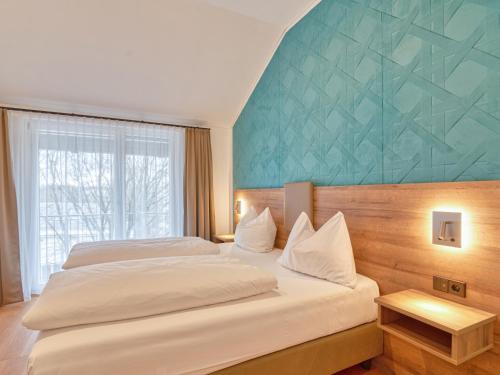 a bedroom with two beds and a large window at WESTSIDE Hotel in Munich