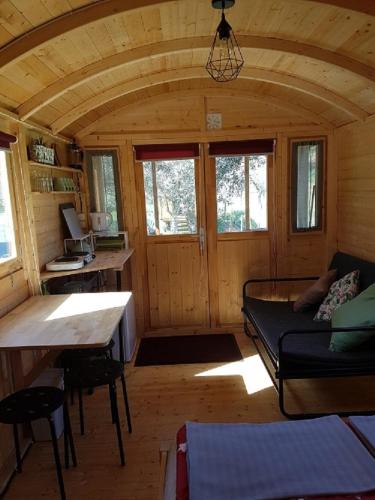 a room with a couch and a table in a cabin at Quinta Portugo in Cernache do Bonjardim