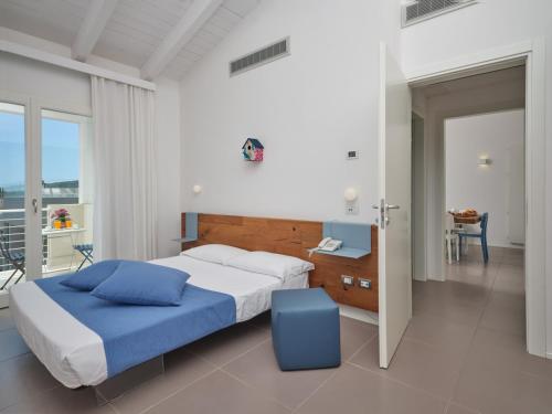 a bedroom with a bed, chair, and a window at Hotel Residence Porto San Paolo in Porto San Paolo