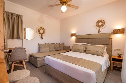a bedroom with a large bed and a couch at Spiros Family Apts in Laganas
