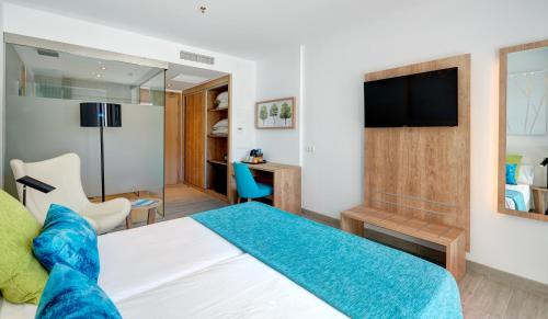 Habitación de hotel con cama y TV en Hotel Moré, en Alcudia