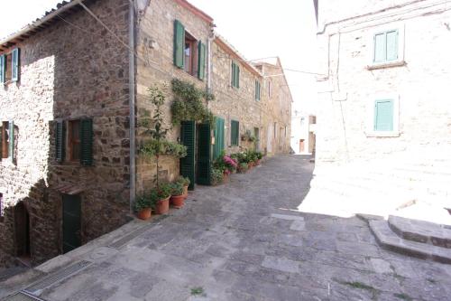 alejka w starym kamiennym budynku z doniczkami w obiekcie antica abitazione con vista montagna Casa Norma w mieście Seggiano