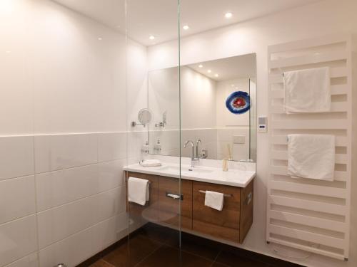 a bathroom with a sink and a glass shower at WESTSIDE Hotel in Munich