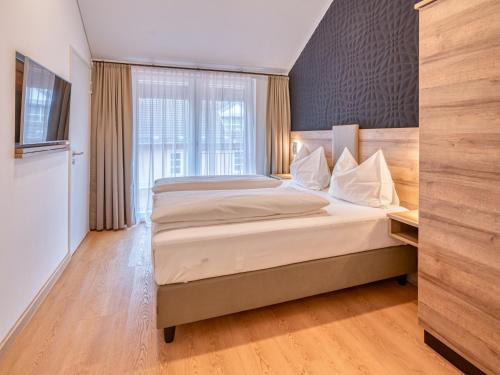 a bedroom with a bed and a large window at WESTSIDE Hotel in Munich