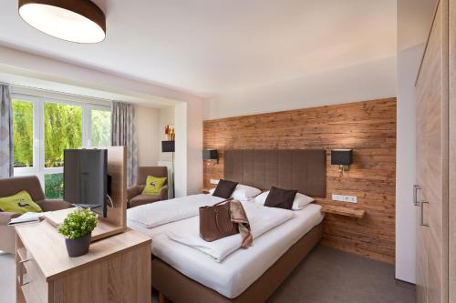 a hotel room with a large bed and a tv at Richstein's Posthotel in Bad Füssing