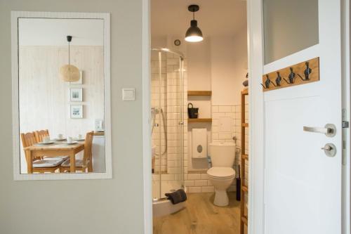 a bathroom with a toilet and a table with a dining room at Dom Rybaka apartament 4 in Ustka
