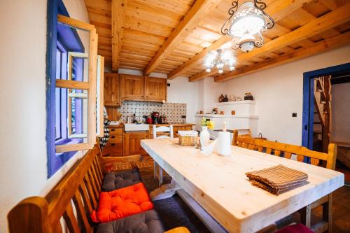 a dining room and kitchen with a wooden table and chairs at Casa lu' Ion in Vişeu de Sus