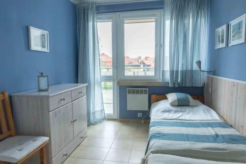 ein kleines Schlafzimmer mit einem Bett und einem Fenster in der Unterkunft Dom Rybaka apartament 4 in Ustka