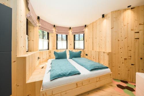 1 dormitorio con 1 cama en una pared de madera en Stadlhof en Maria Alm am Steinernen Meer