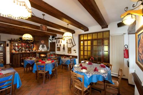 un comedor con mesas y sillas azules en Hotel Palavas, en Villar Pellice