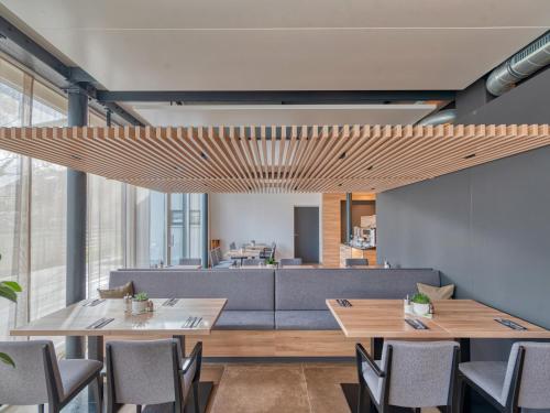 a dining room with tables and a couch at WESTSIDE Hotel in Munich