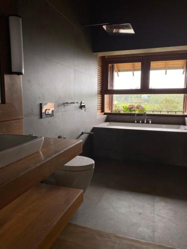a bathroom with a toilet and a sink and a tub at Atulya Villas Nuwara Eliya in Nuwara Eliya