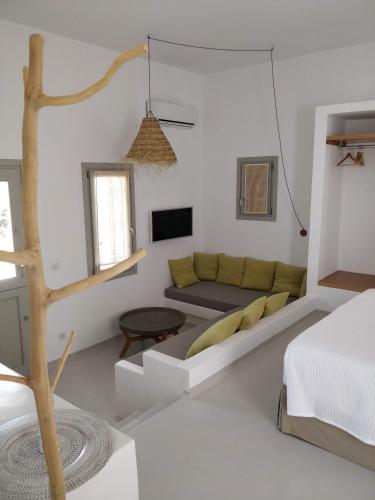 a white room with a couch and a bed at Psathaki in Kimolos