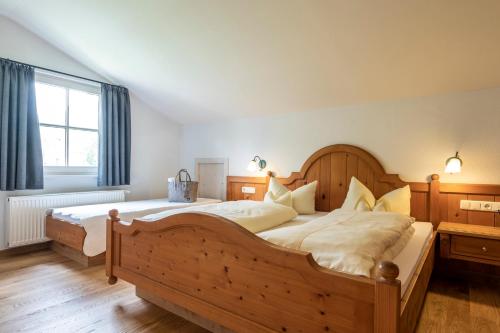 a bedroom with a large wooden bed and a window at Naturhotel Lärchenhof in Mittelberg