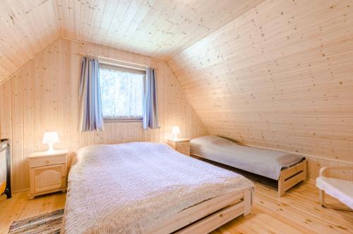 sypialnia z łóżkiem i oknem w pokoju w obiekcie Aurum domki w mieście Jarosławiec