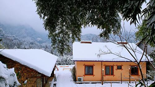 a house with snow on the roof of it at Forest Glass inn in Zhangjiajie