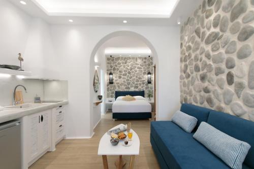 a living room with a blue couch and a bed at Hora Seaside Suites in Naxos Chora
