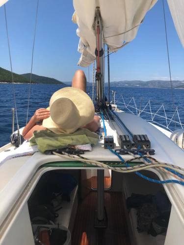 a man on a boat with a hat on the deck at Villa Anica Dubrovnik - luxurious with a sea view in Dubrovnik