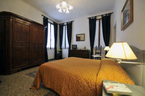 a bedroom with a bed and a dresser and windows at Ca' Turelli in Venice