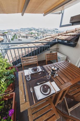 a wooden table and chairs on a balcony at Cute & Cozy Terrace in Bergamo